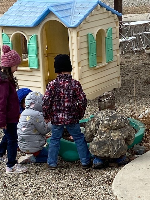 Some kids watch while others bring a handful of worms to the garden.